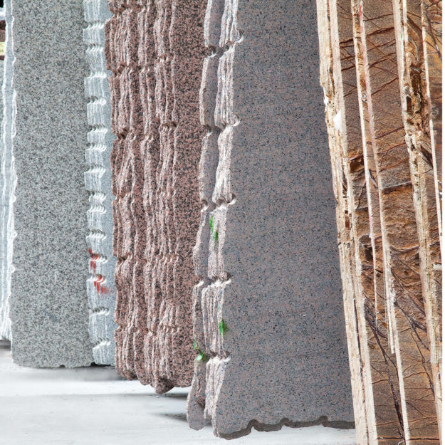 Aneinander gelehnte Granitplatten, die noch unbehandelt sind.