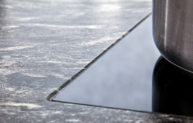 Nahaufnahme einer Granitarbeitsplatte und einer Kochplatte.